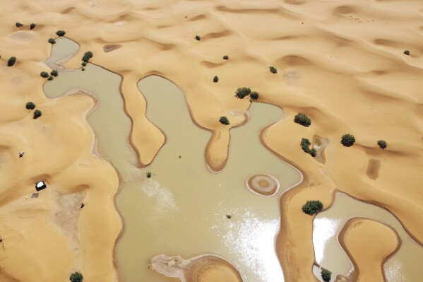 Water gushes through sand dunes after a rare rainfall in Moroccan Sahara desert 