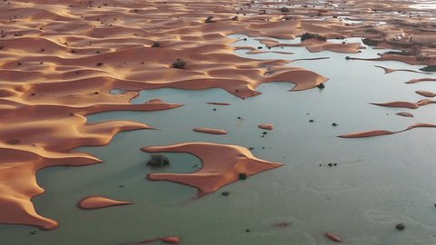 Water gushes through sand dunes after a rare rainfall in Moroccan Sahara desert 