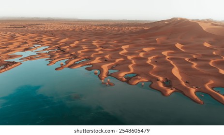 Water gushes through sand dunes after a rare rainfall in Moroccan Sahara desert 